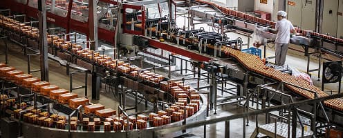 Carbonated drink bottles moving through a beverage factory production line