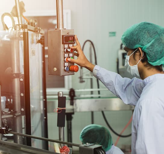 Staff workers operating control machine in hygiene food factory.