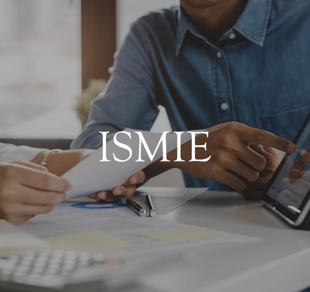 ISMIE Mutual Insurance Company logo with a background featuring two businesspeople sitting with a tablet and some papers.