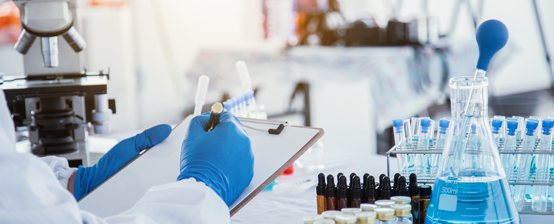 Scientific researcher researching Multi-colored solution by wearing blue gloves and white clothing