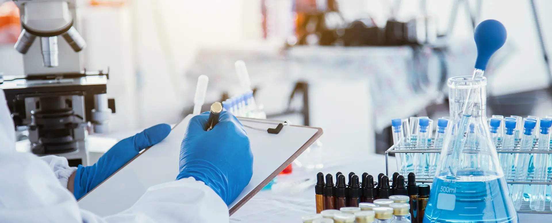 Scientific researcher researching Multi-colored solution by wearing blue gloves and white clothing