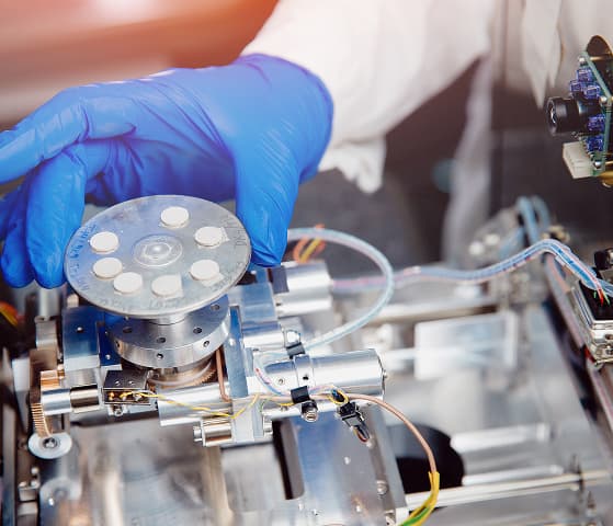 Chemist preparing pills for testing on a pharmaceutical production line
