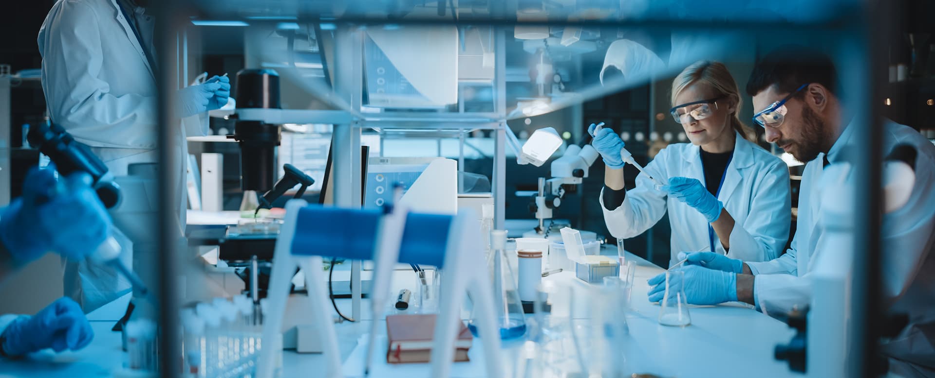 Medical researchers discussing liquid samples during lab experiments