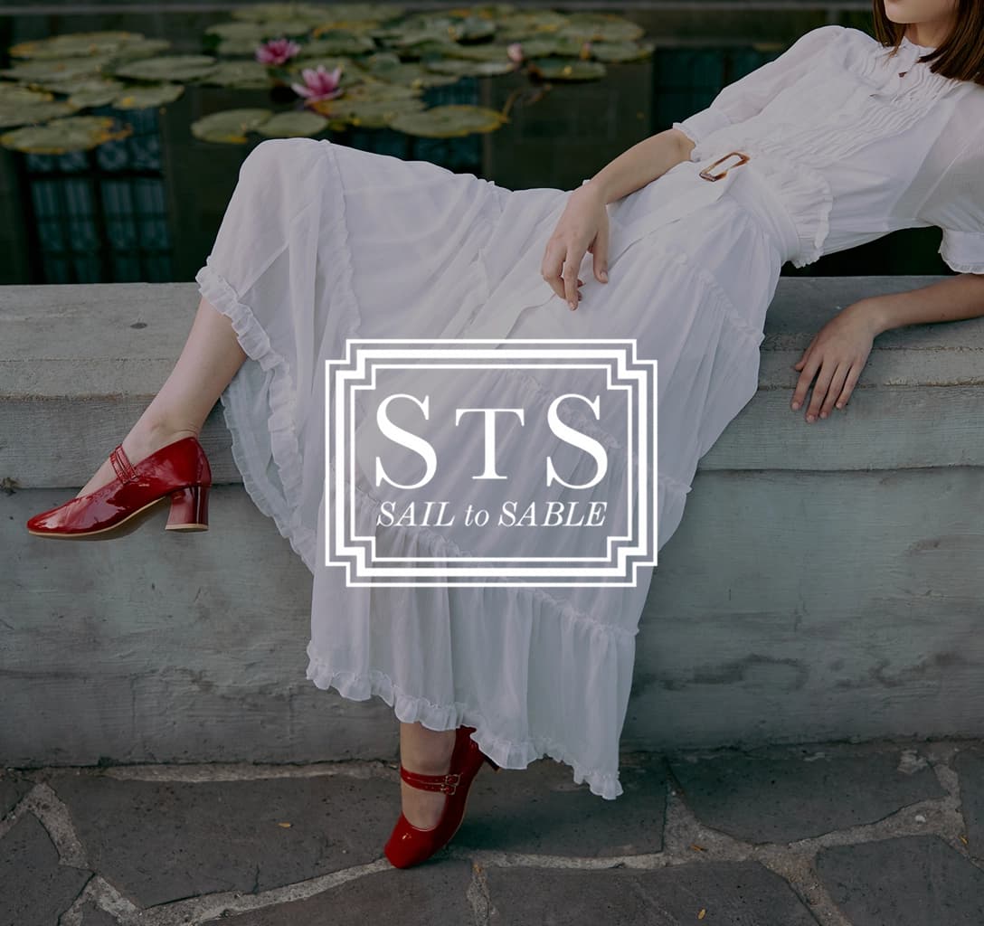 The Sail to Sable logo, featuring a woman in a white dress and red shoes.