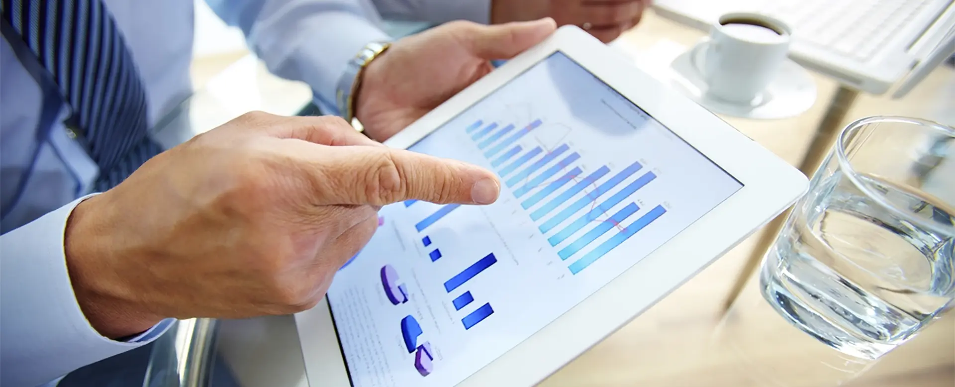 Finger pointing at tablet with figures.