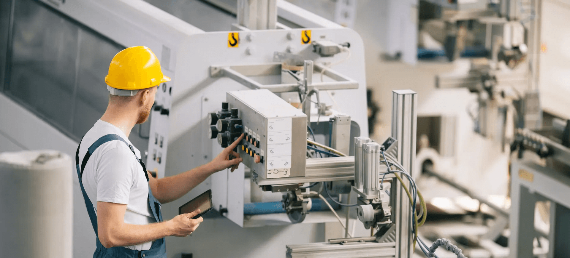 Factory maintenance worker inspecting a machine.