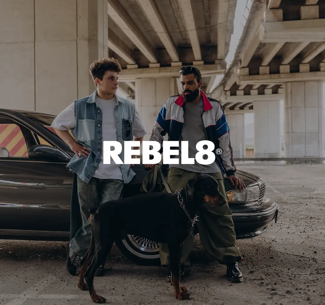 REBEL8 logo with a background showing two guys leaning against a car.
