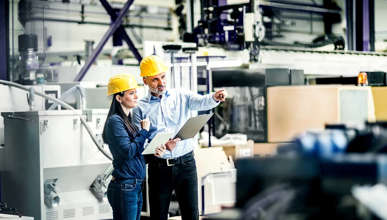 Mann und Frau mit Plan von der Materialwirtschafts-Software