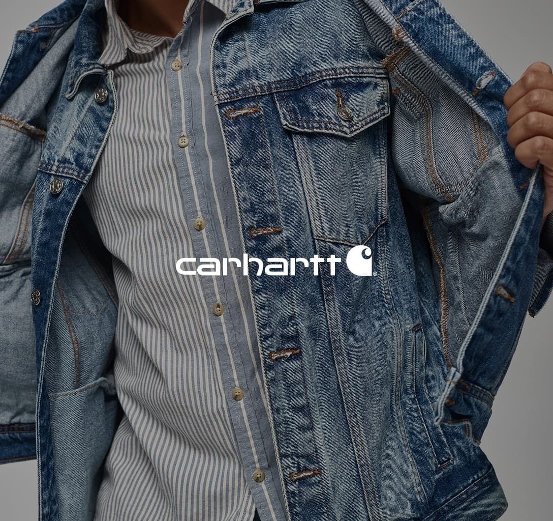 Carhartt logo with a model wearing a denim jacket in the background.