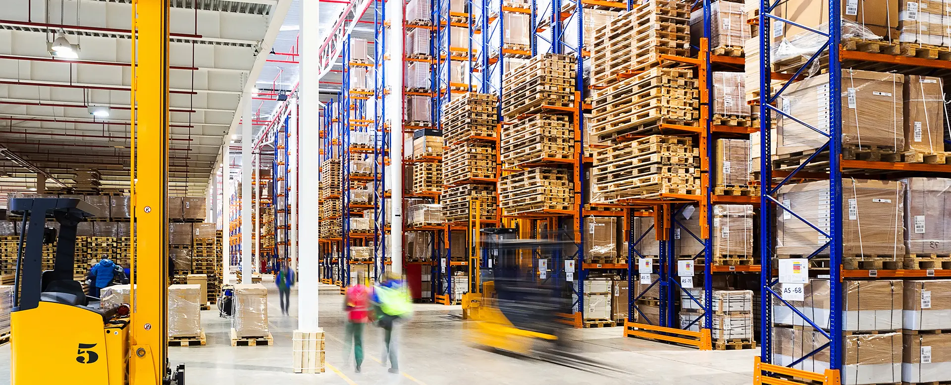 Workers operating inside a modern large warehouse