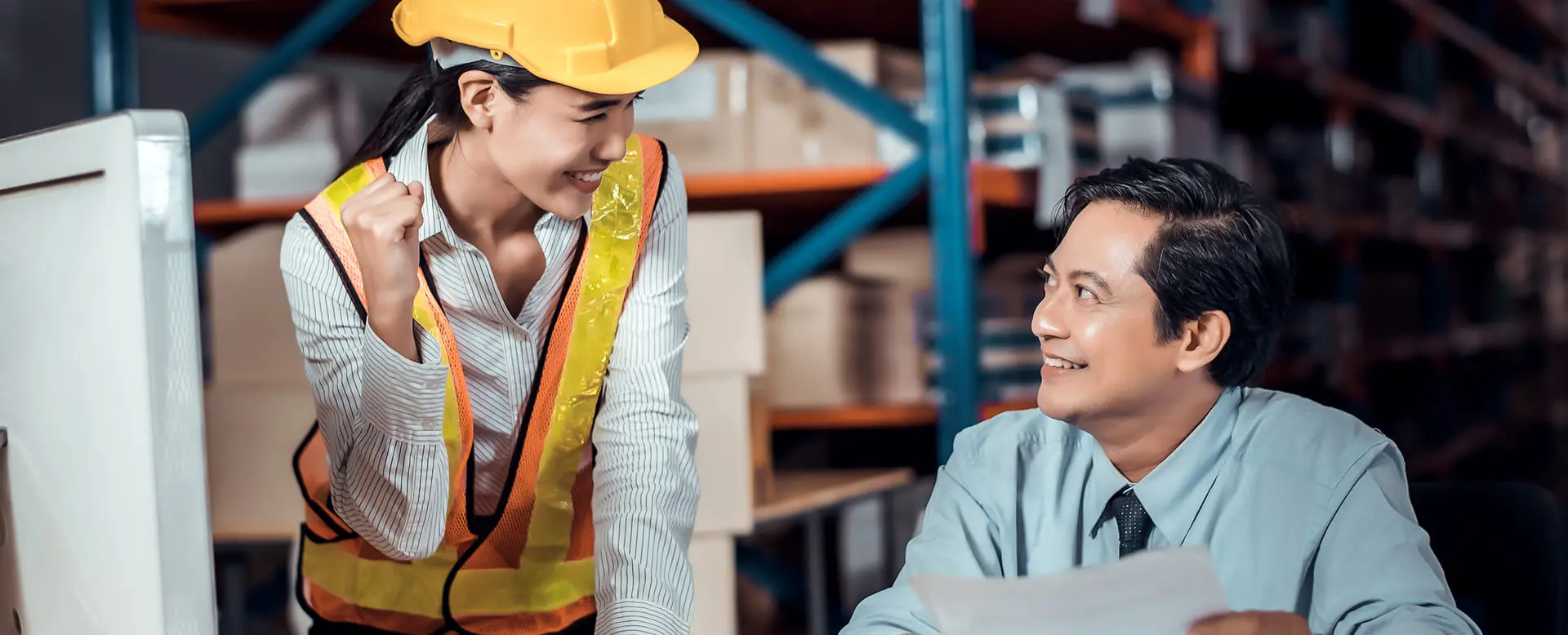 Warehouse worker and manager reviewing documents in distribution center