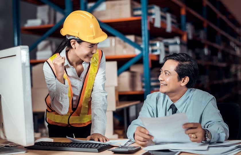 Warehouse worker and manager reviewing documents in distribution center