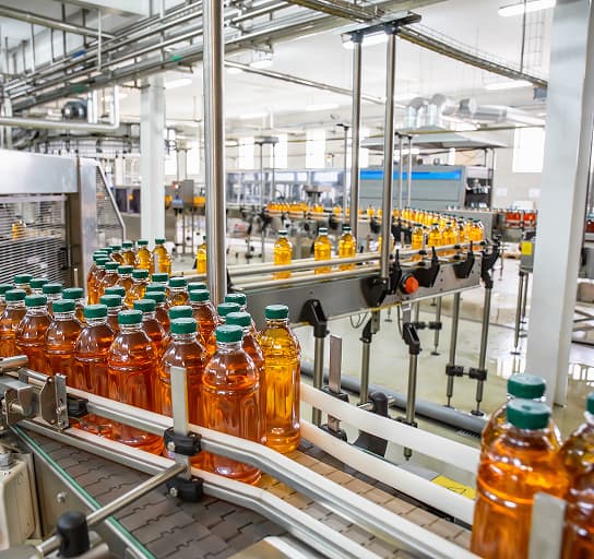 Fresh juice bottles on an automated beverage plant conveyor line