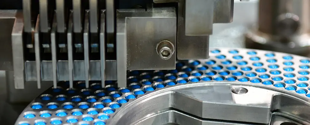 Blue capsule pills moving through a pharmaceutical production line
