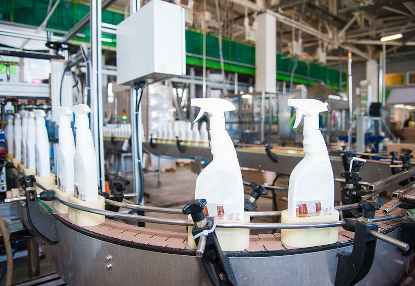 Liquid detergent being poured into a bottle on a production line